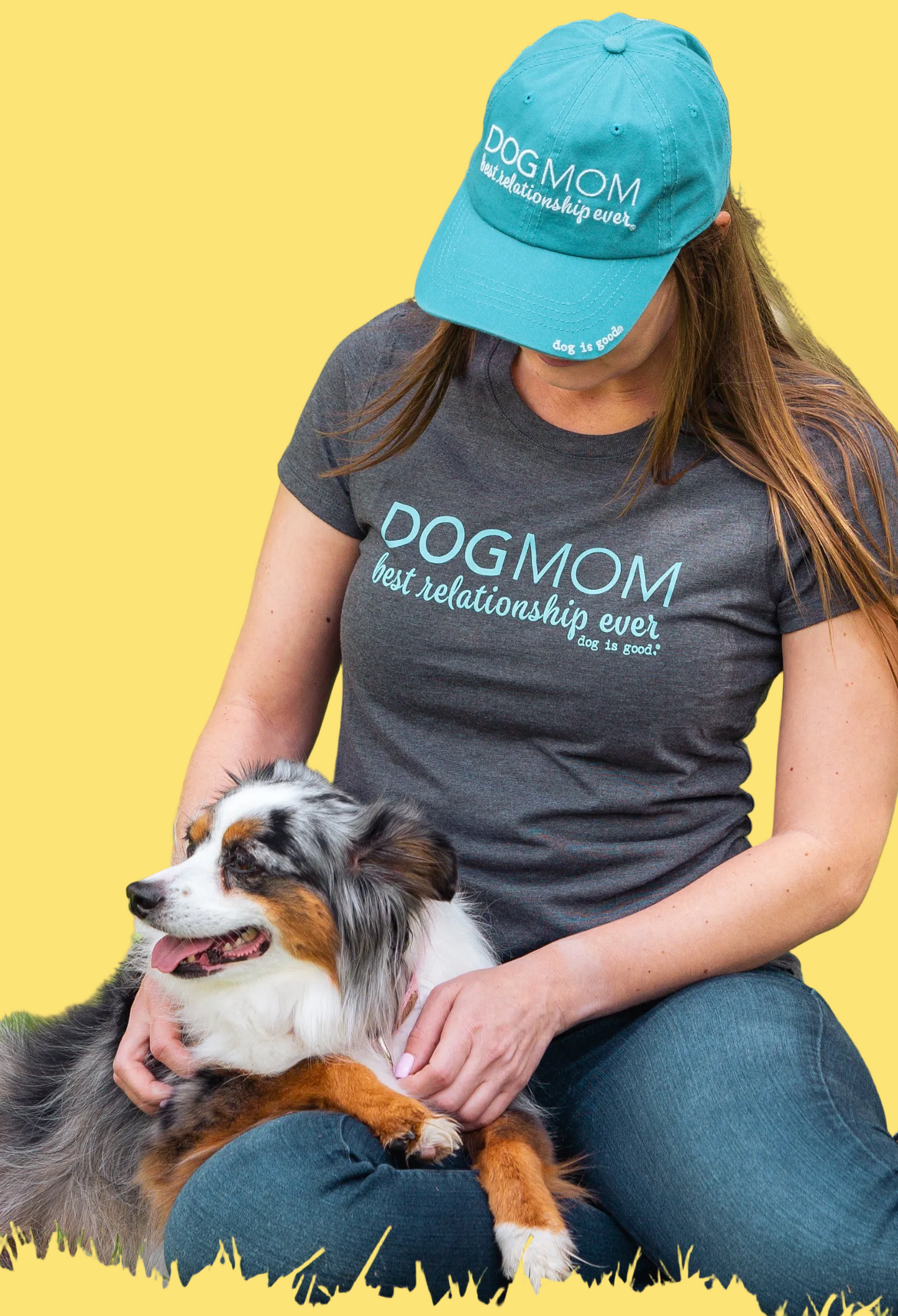 Person wearing a 'Dog Mom best relationship ever' shirt and cap, sitting with a dog outdoors.
