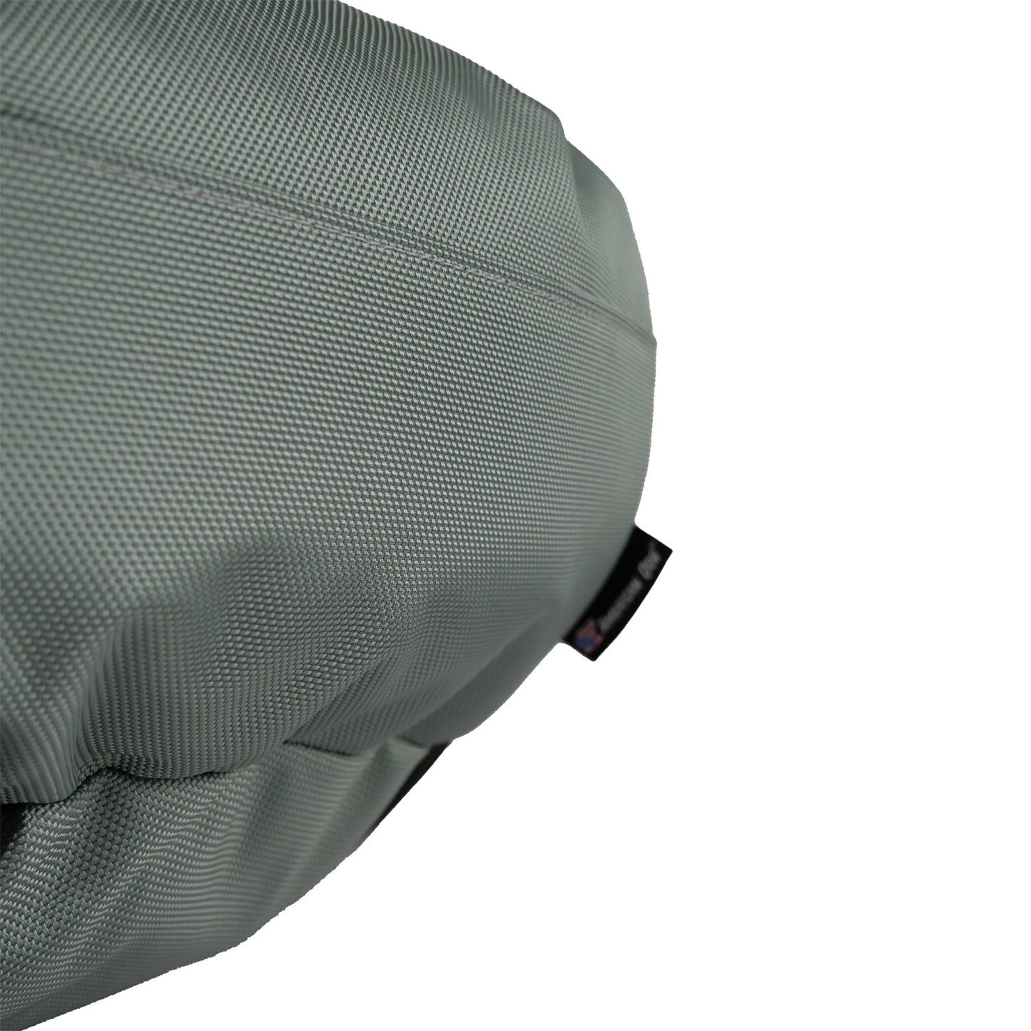 Close-up of a textured gray seat cover with a brand logo on a white background