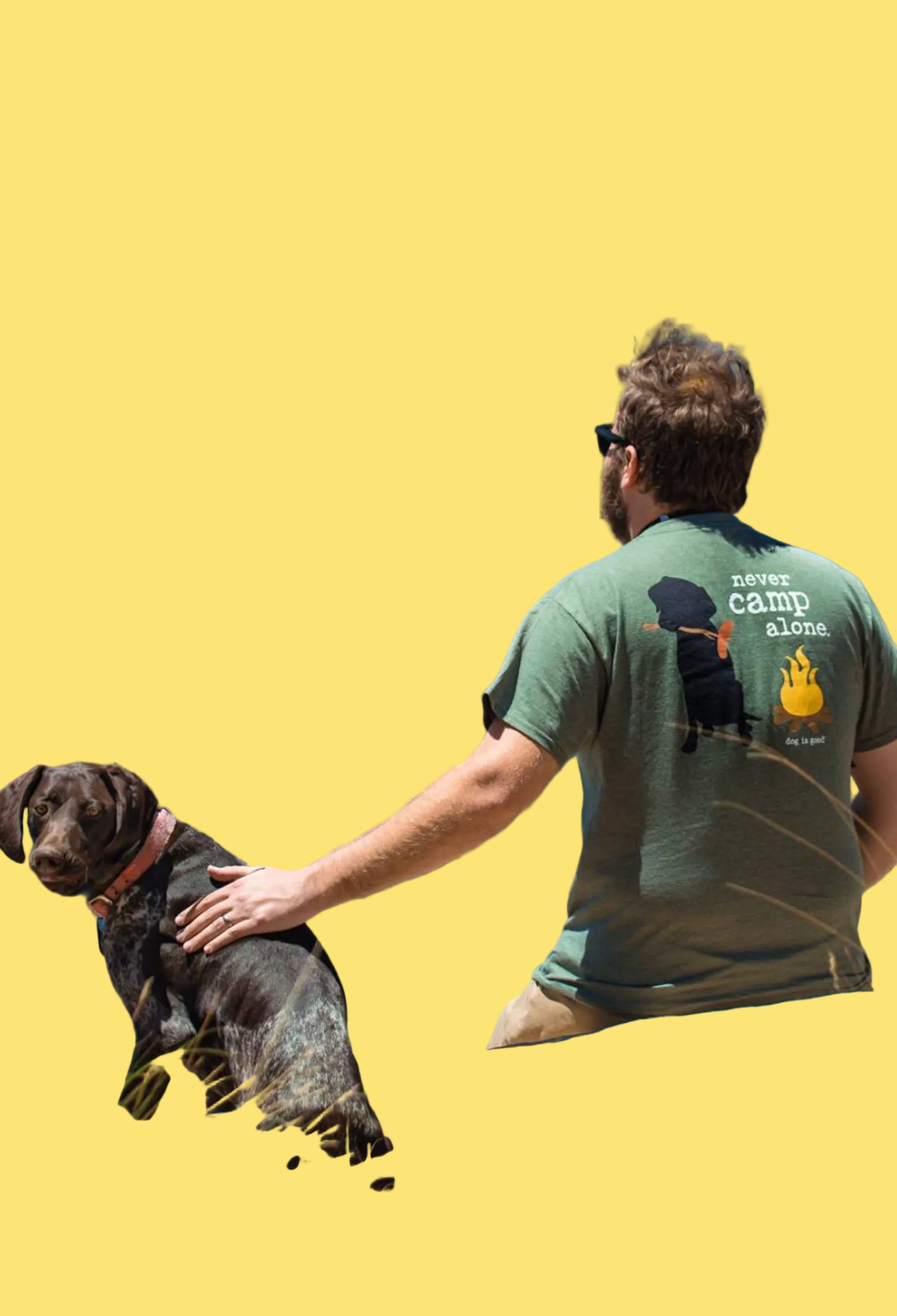 Man and dog sitting on a log overlooking a mountainous landscape