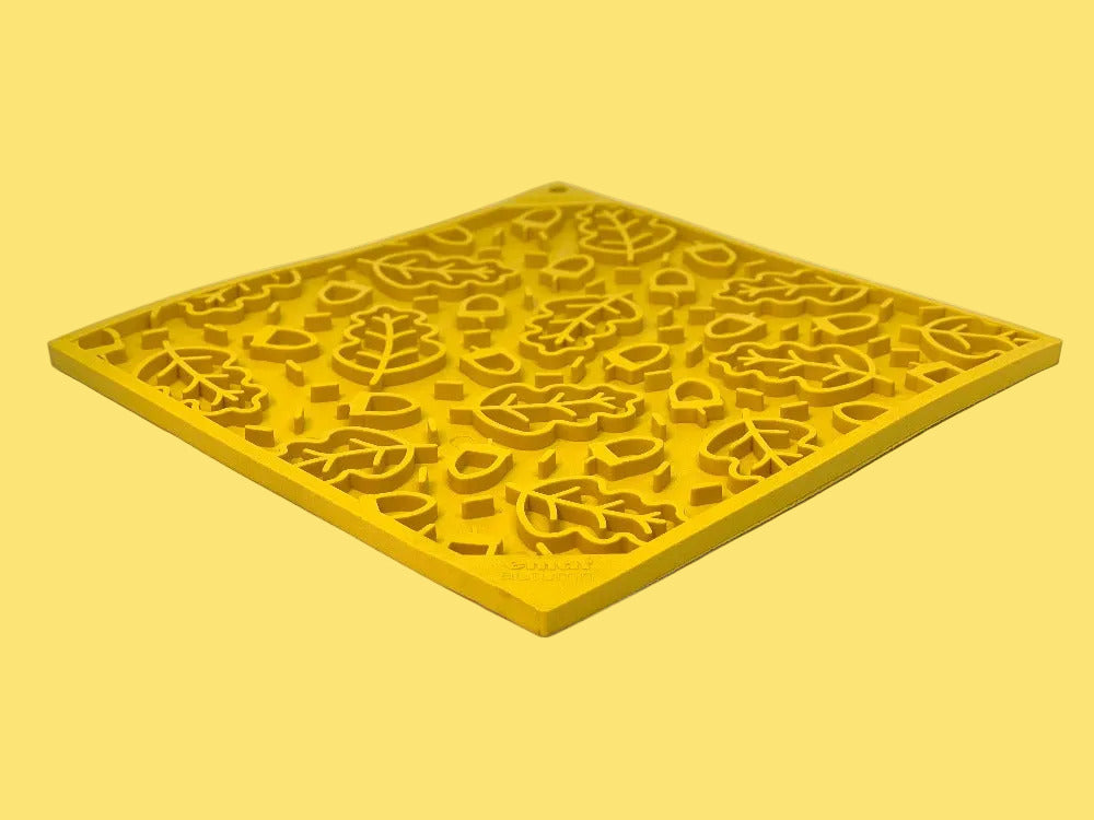 Yellow decorative mat with intricate cut-out patterns on a white background