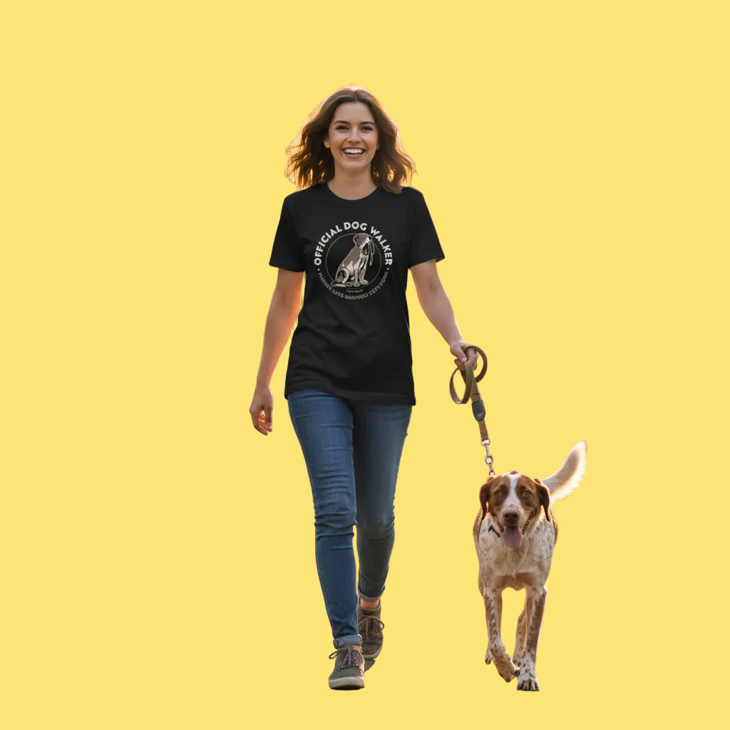 Woman walking a dog on a yellow background wearing a black t-shirt with a graphic design.