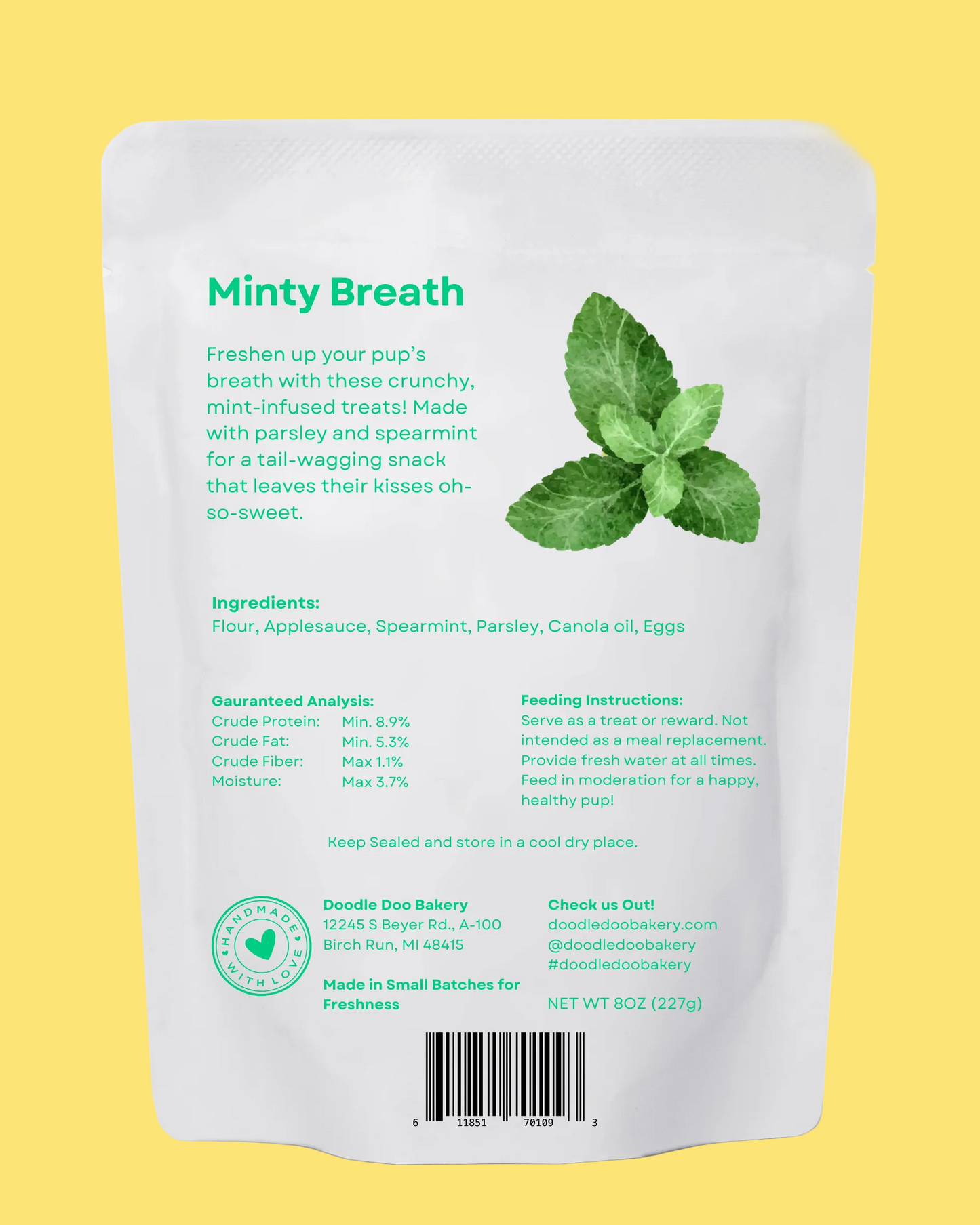 Back of a white packaging pouch with green text and mint leaves, labeled 'Minty Breath' for dog treats.
