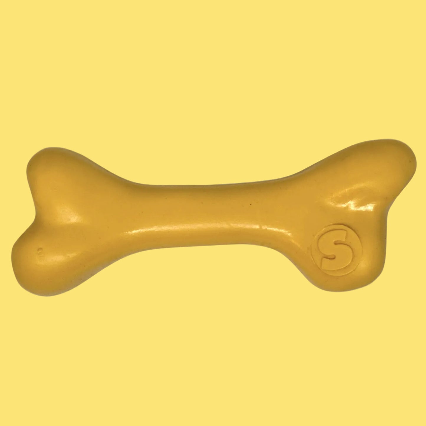 Yellow bone-shaped toy with a visible brand logo on a white background